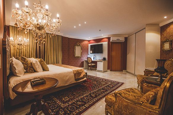 Um quarto de hotel com uma parede de tijolos e pinturas na parede.