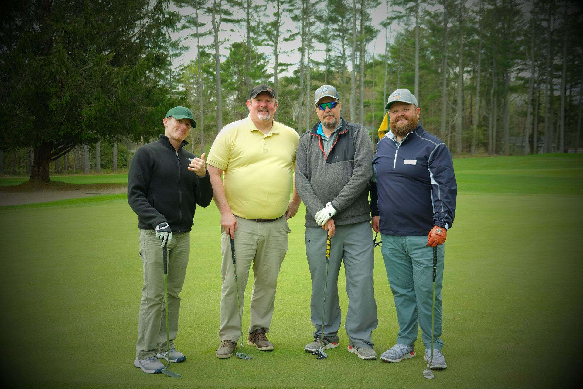 A group of men are posing for a picture on a golf course.