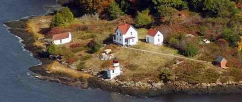 An aerial view of a small island with houses and a lighthouse
