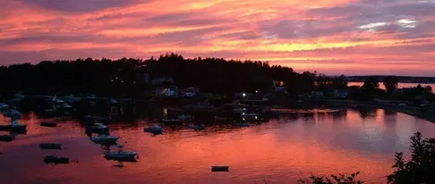 A sunset over a body of water with boats in it