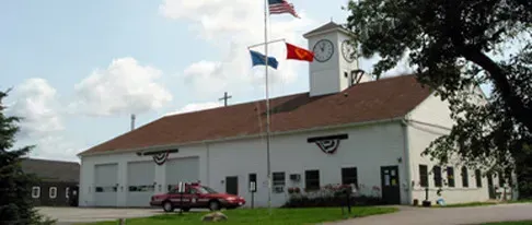 A white building with a red truck parked in front of it