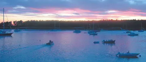A sunset over a body of water with boats in it