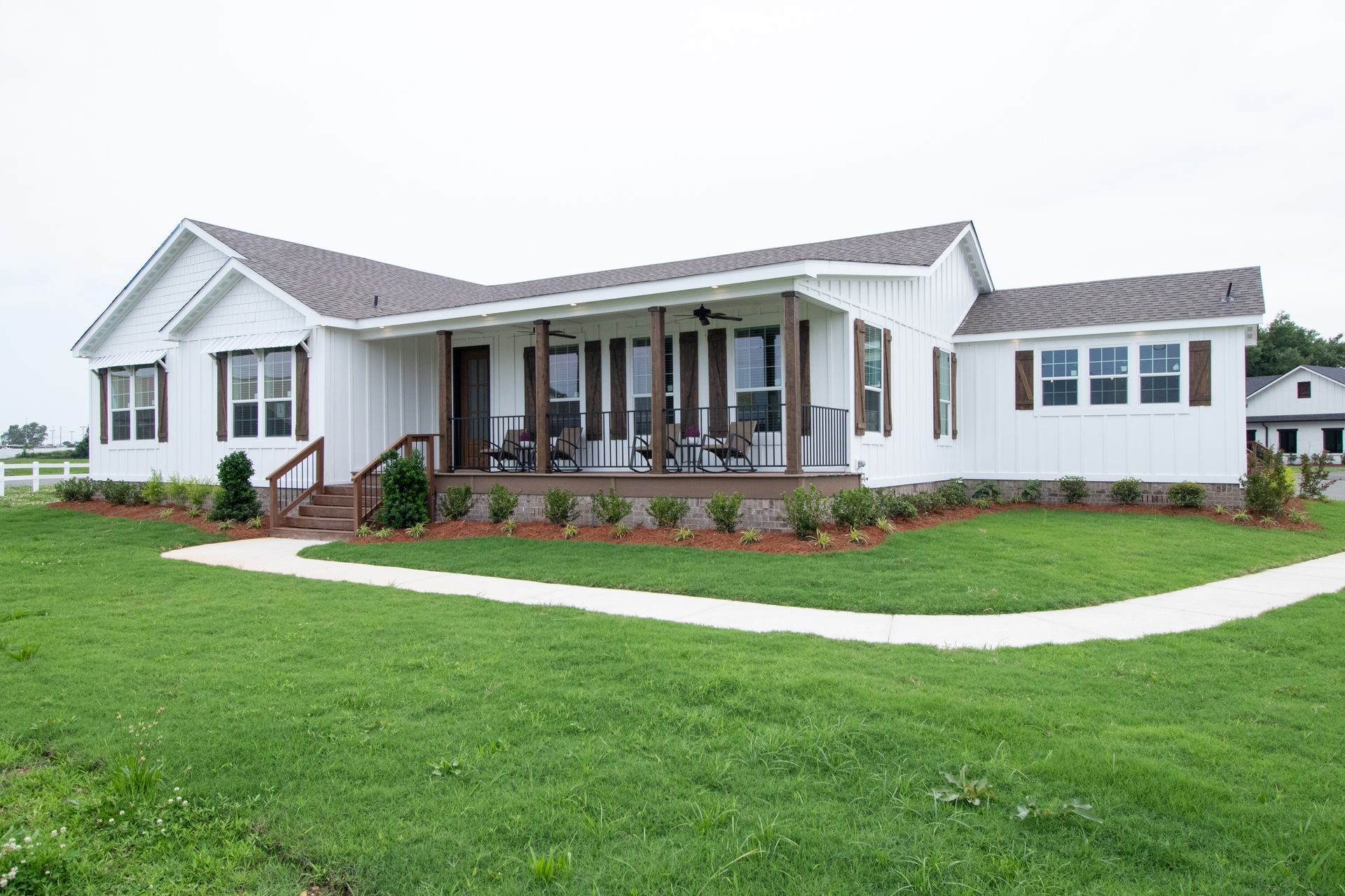 Single-story white house with a covered porch, front steps, and a green lawn