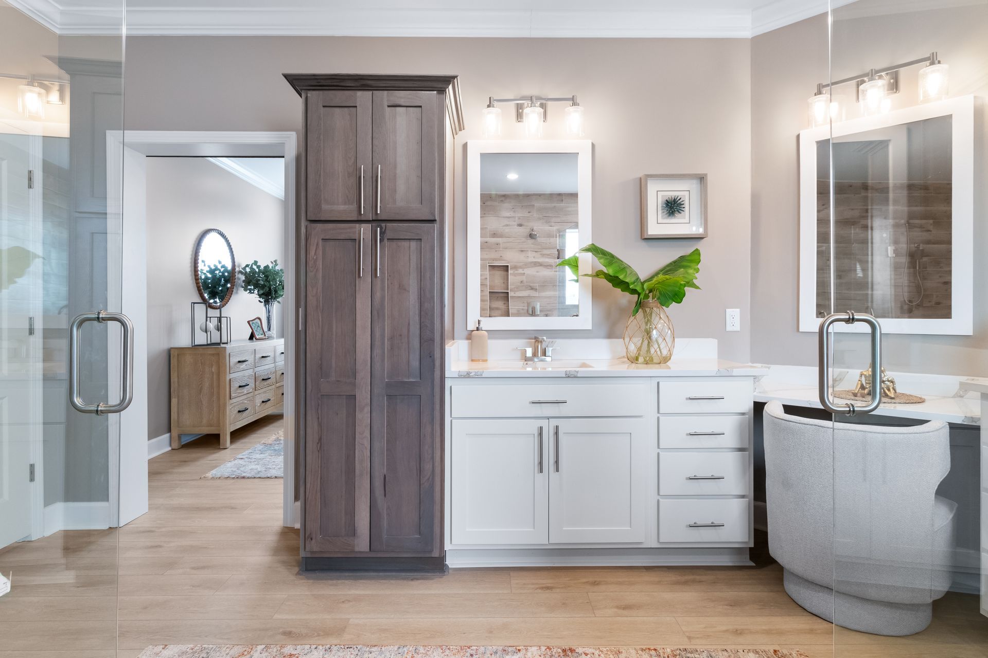 Modern bathroom with double vanity, large mirrors, dark wood cabinet, and freestanding tub in neutral tones