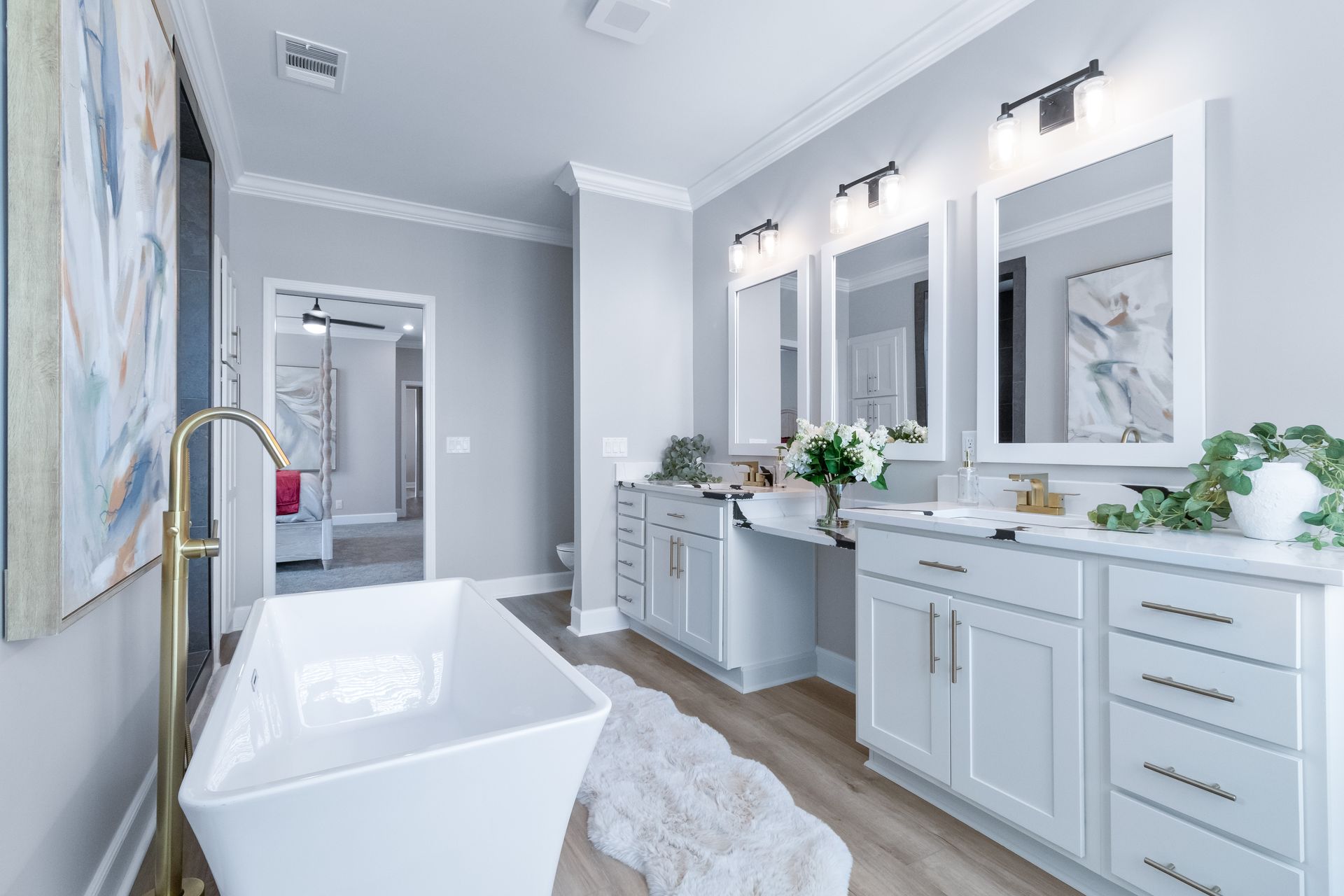 Bright modern bathroom with a freestanding tub, double vanity, large mirrors, and gray-and-white decor