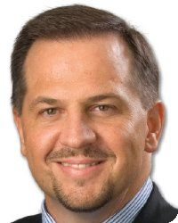 Smiling man in suit and striped shirt.