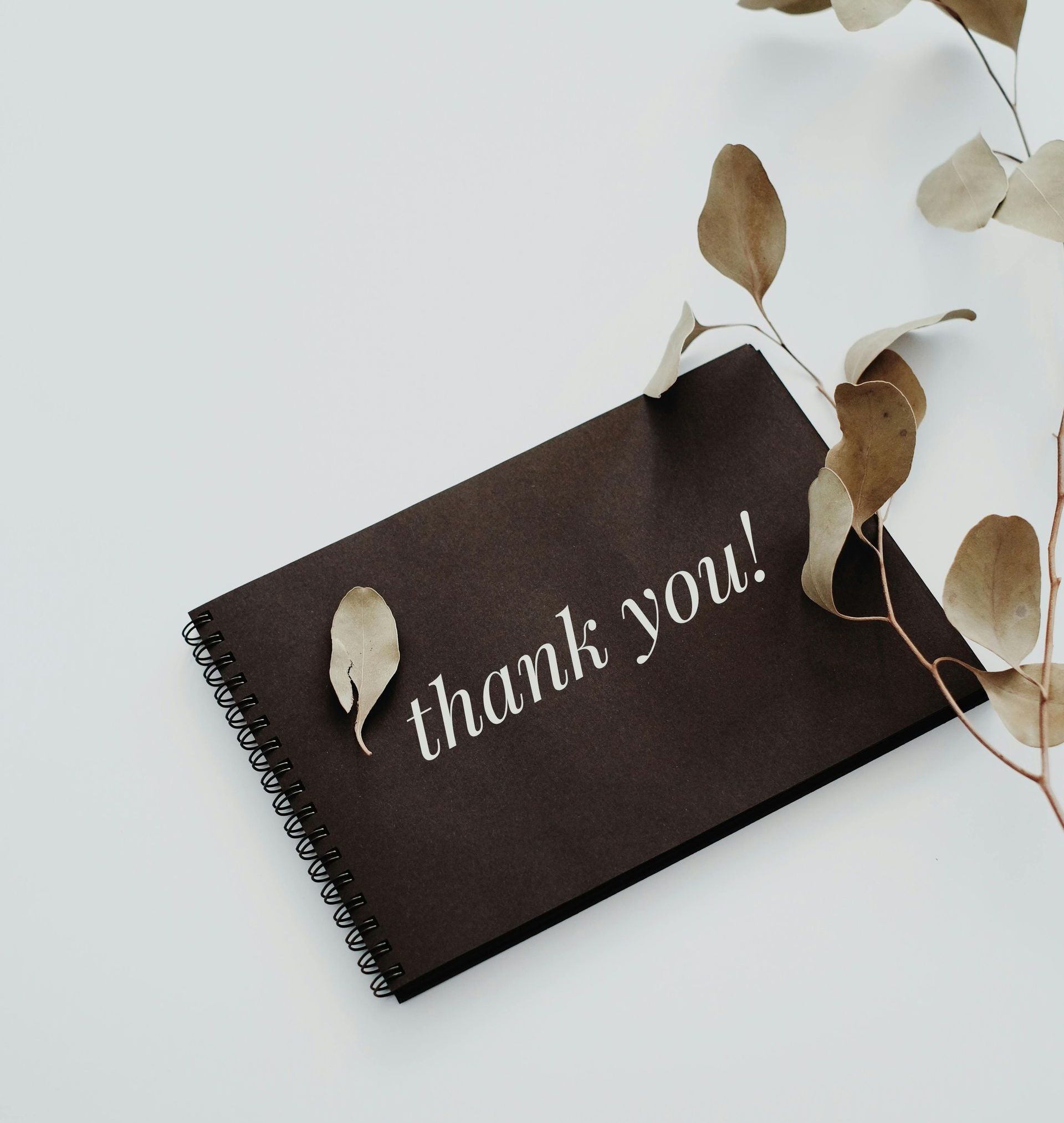 A thank you card is sitting on a white surface