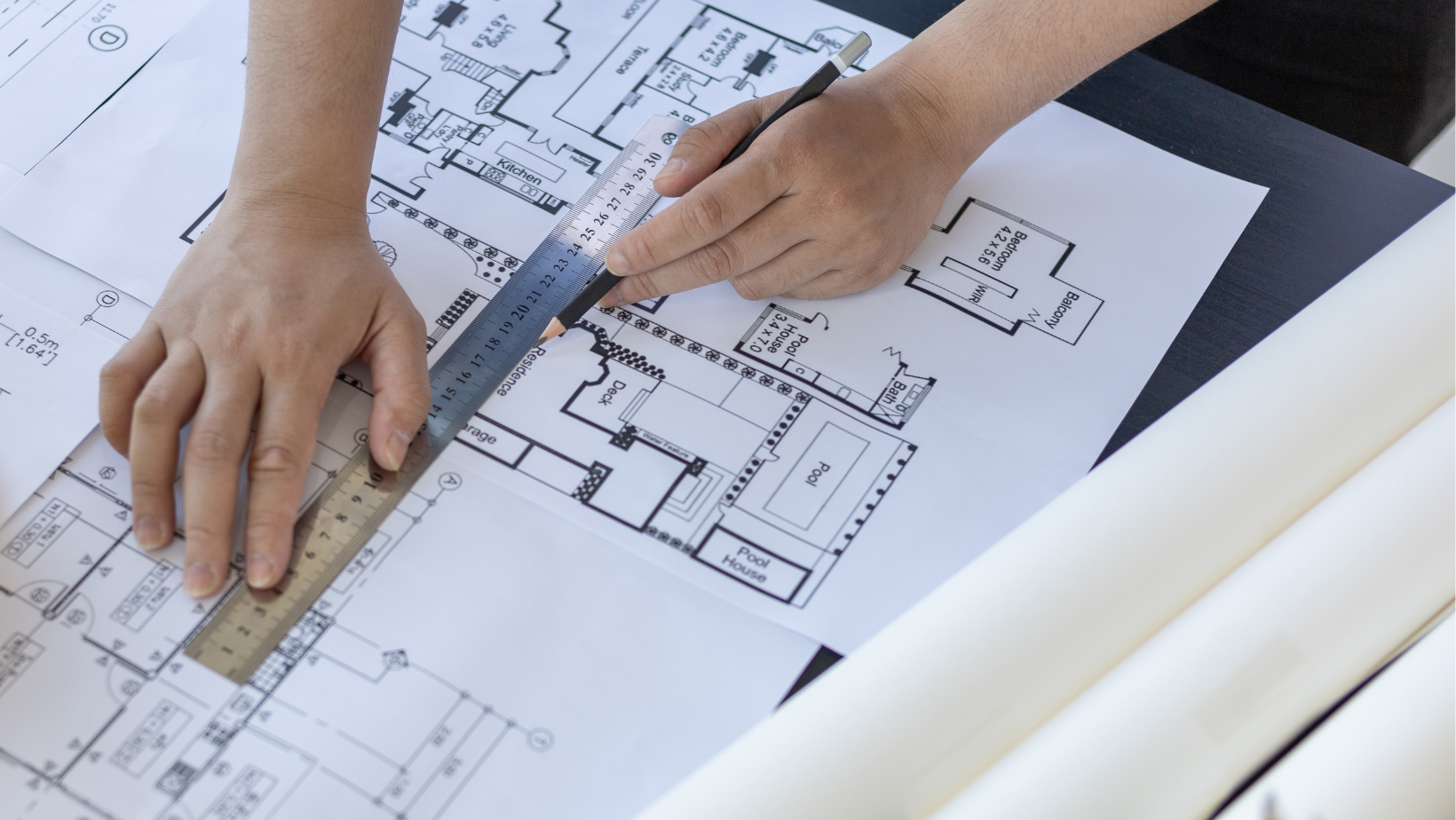 a person is using a ruler to measure a floor plan .