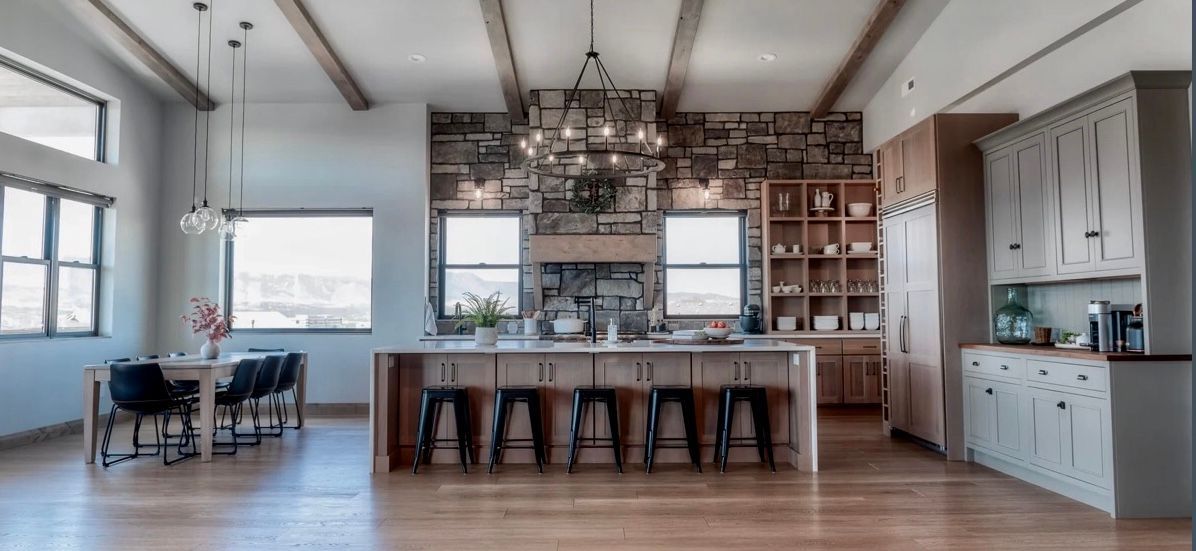 a kitchen with gray cabinets and stainless steel appliances and a large island .
