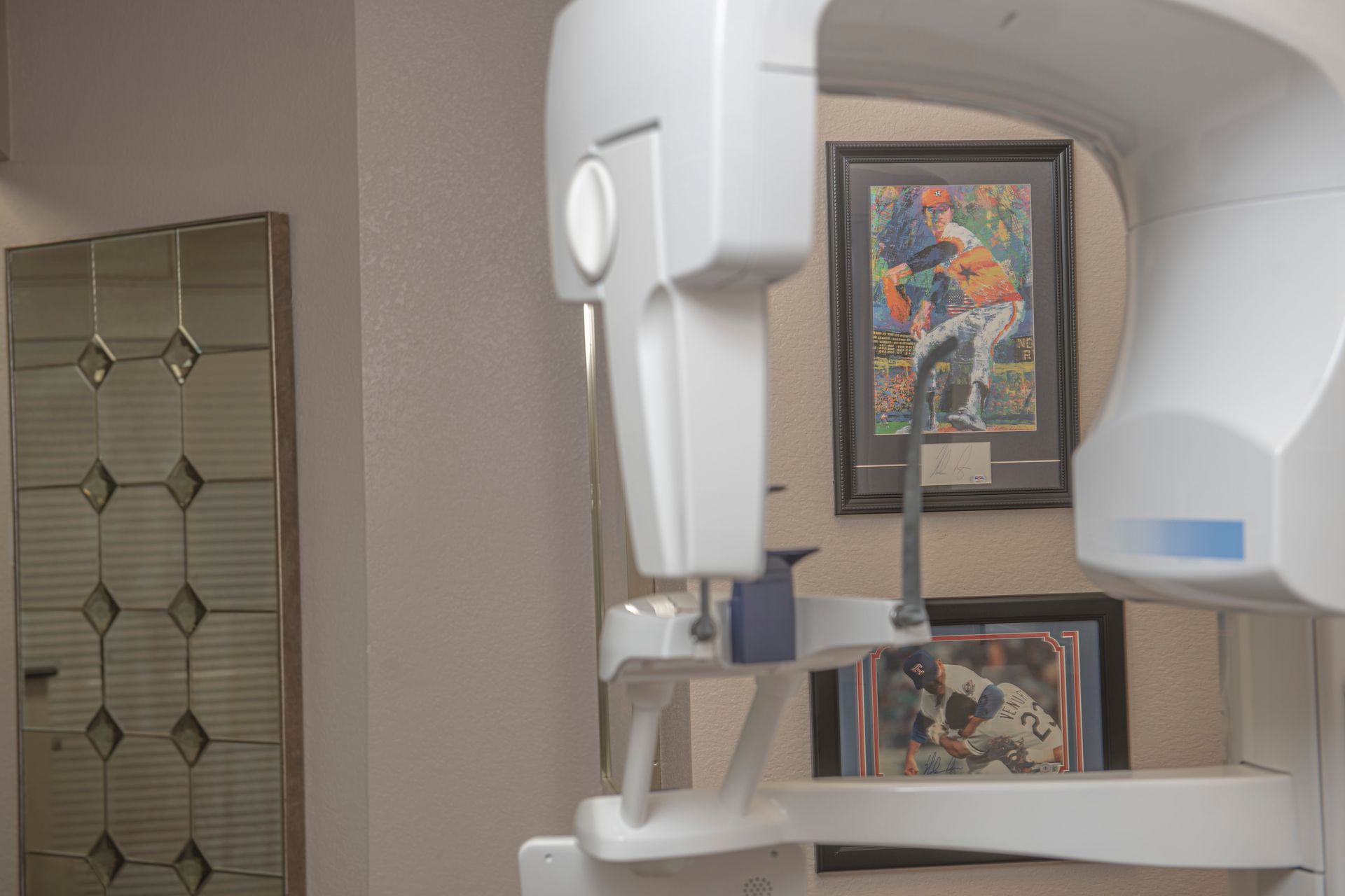 A dental office with a x-ray machine and paintings on the wall.