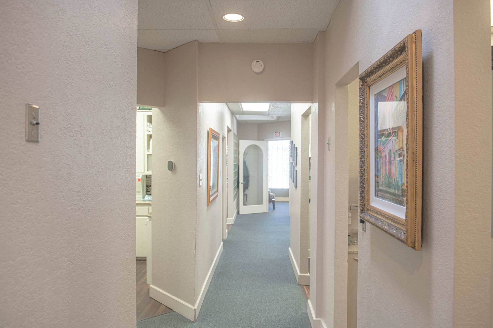 A hallway in a dental office with a picture on the wall.