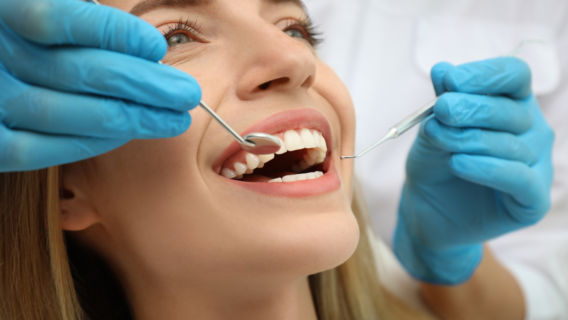 A woman is getting her teeth examined by a dentist.