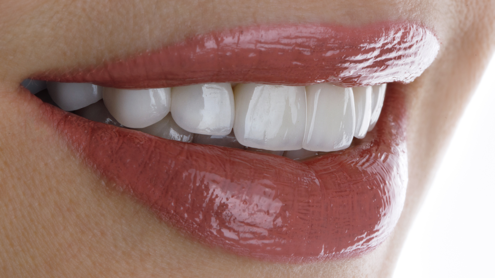 a close up of a woman 's mouth with white teeth and red lips .