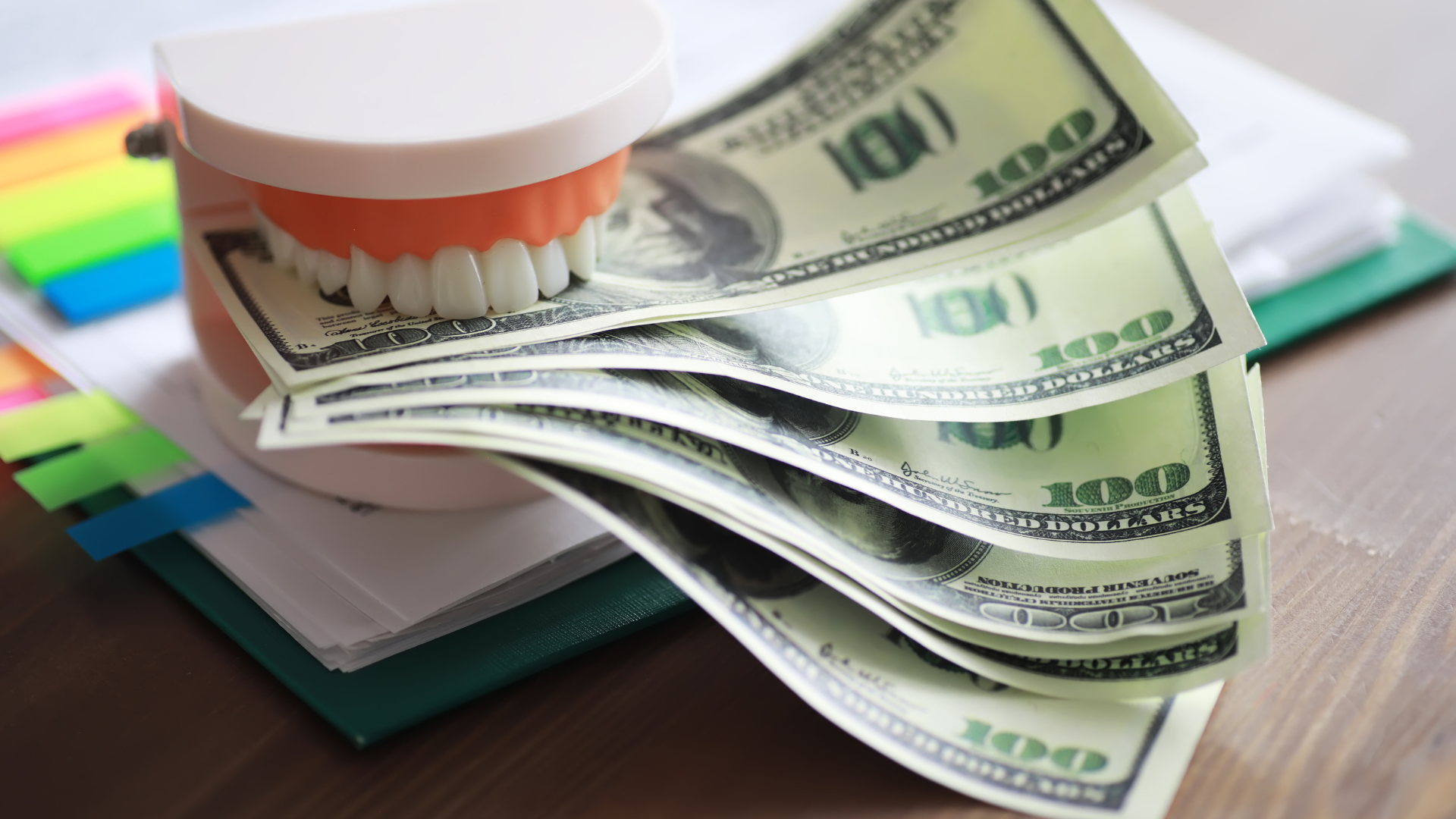 a dental model is sitting on top of a pile of money .