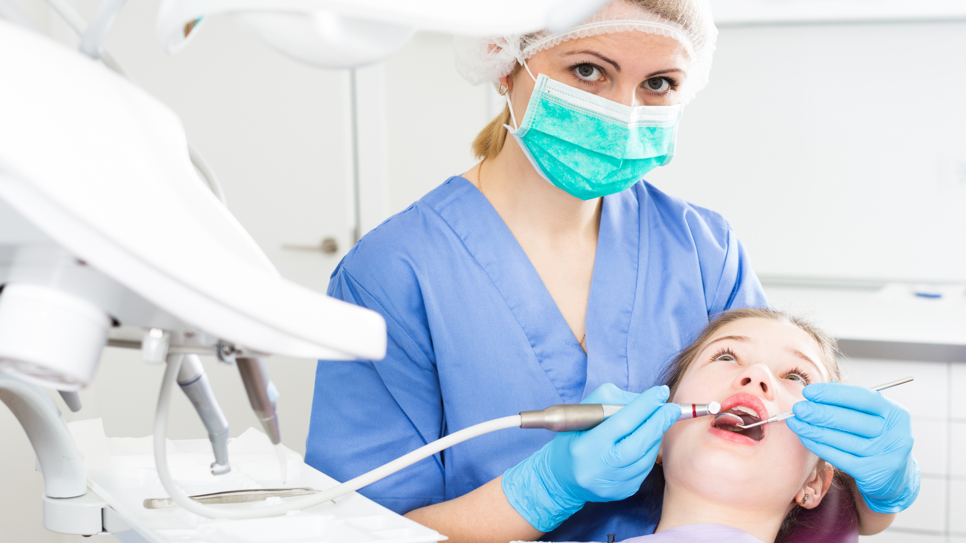 Dentist showing a patient a model of teeth in a dental office.