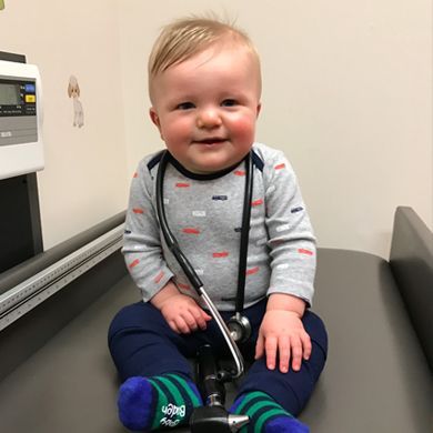 Smiling baby on pediatrician exam table with stethoscope