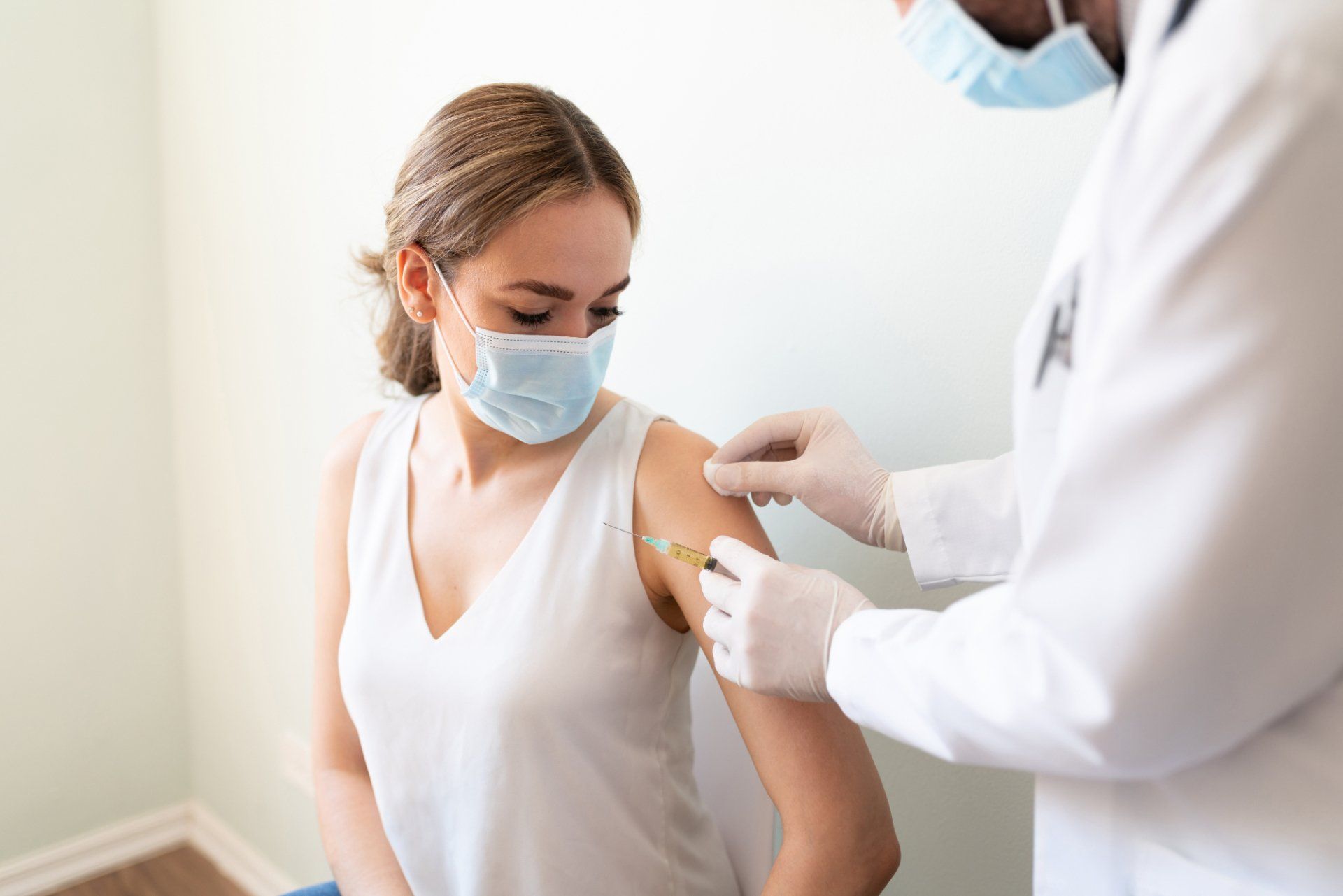 woman receives vaccine from doctor