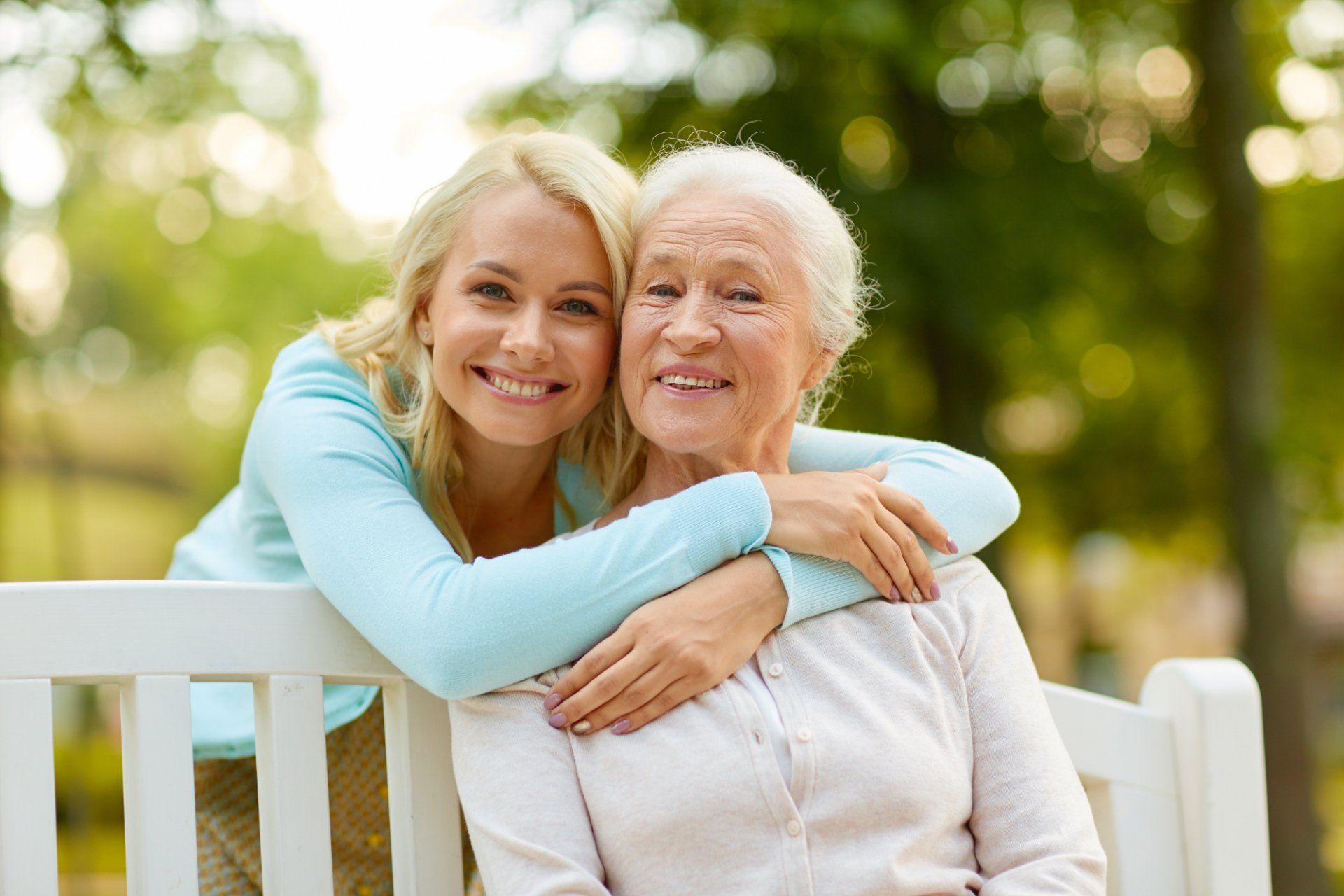 mature woman hugging elderly mother