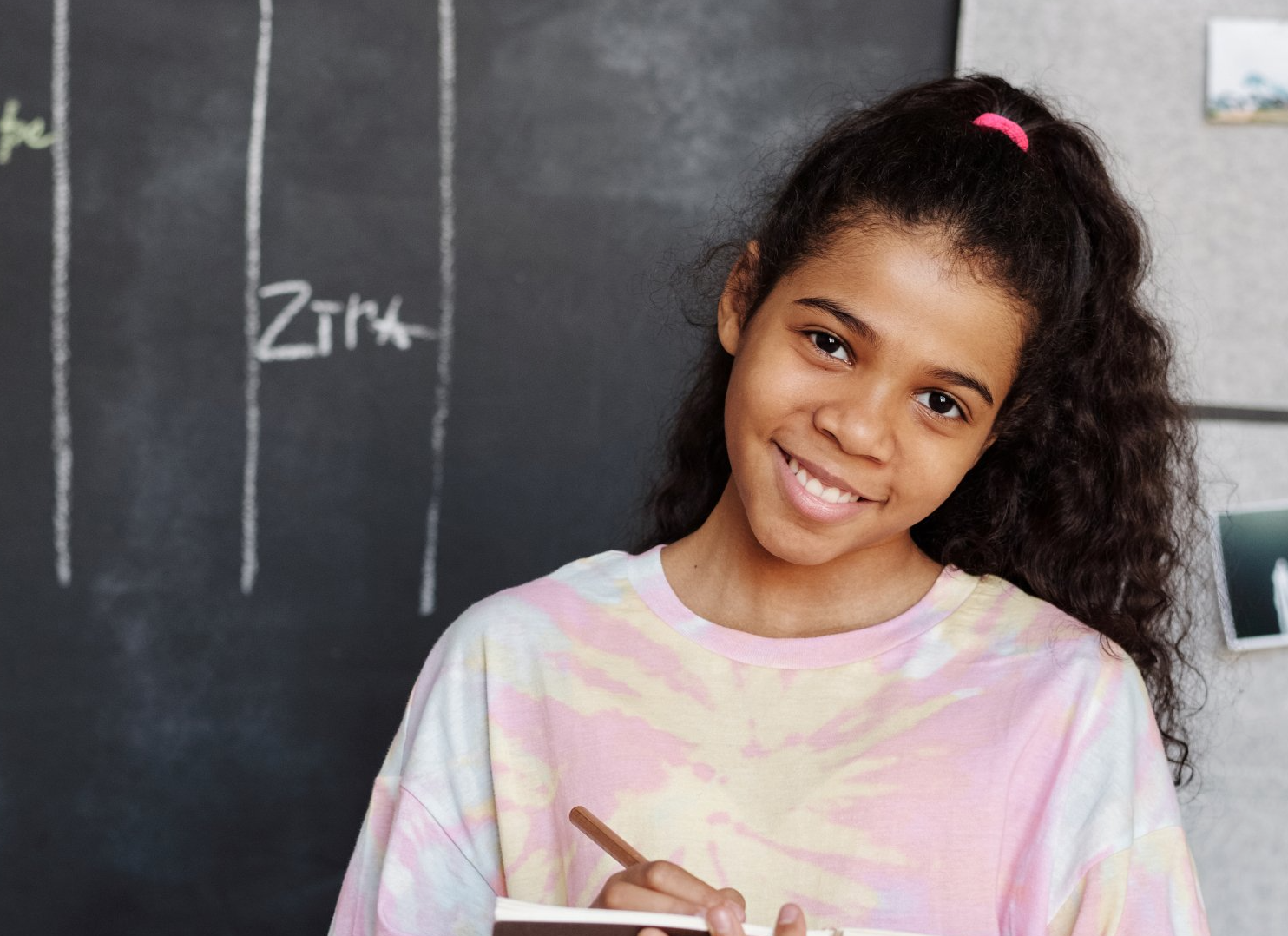 preteen girl in front of school chalkboard