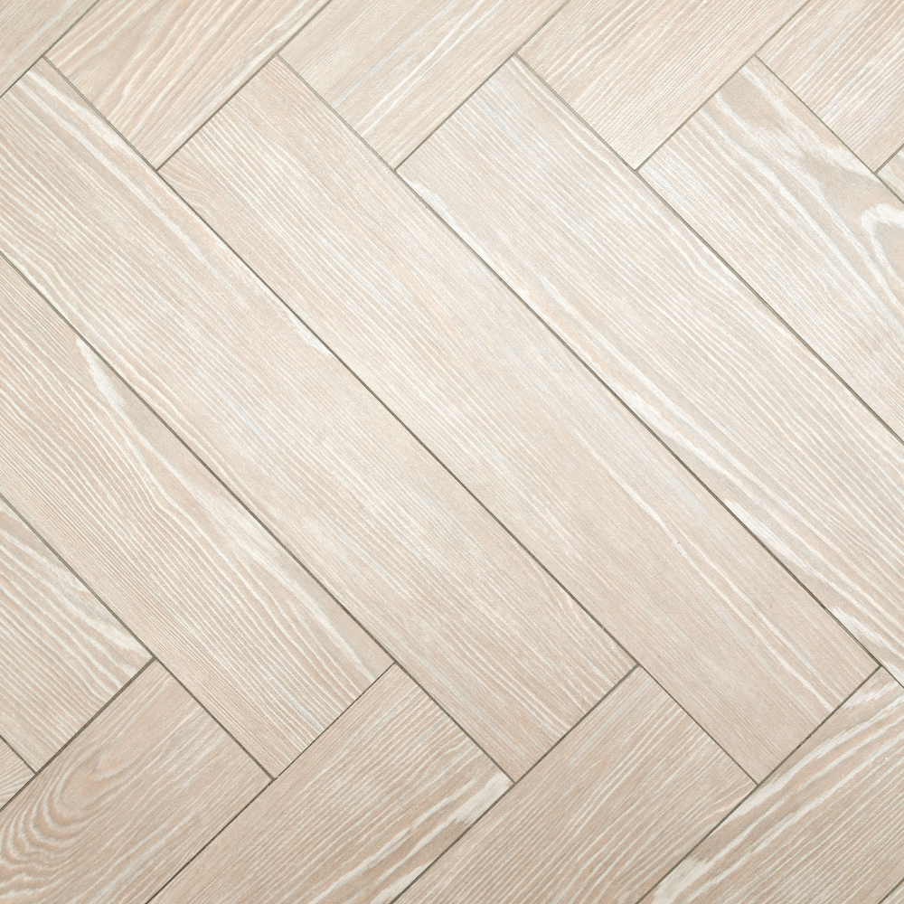 Light-colored wood flooring planks arranged in a diagonal herringbone pattern.