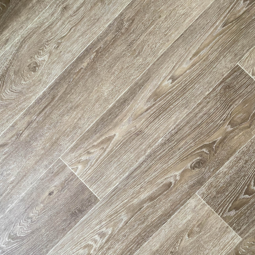 Light brown wood-look flooring planks with a weathered grain pattern arranged in a diagonal pattern.