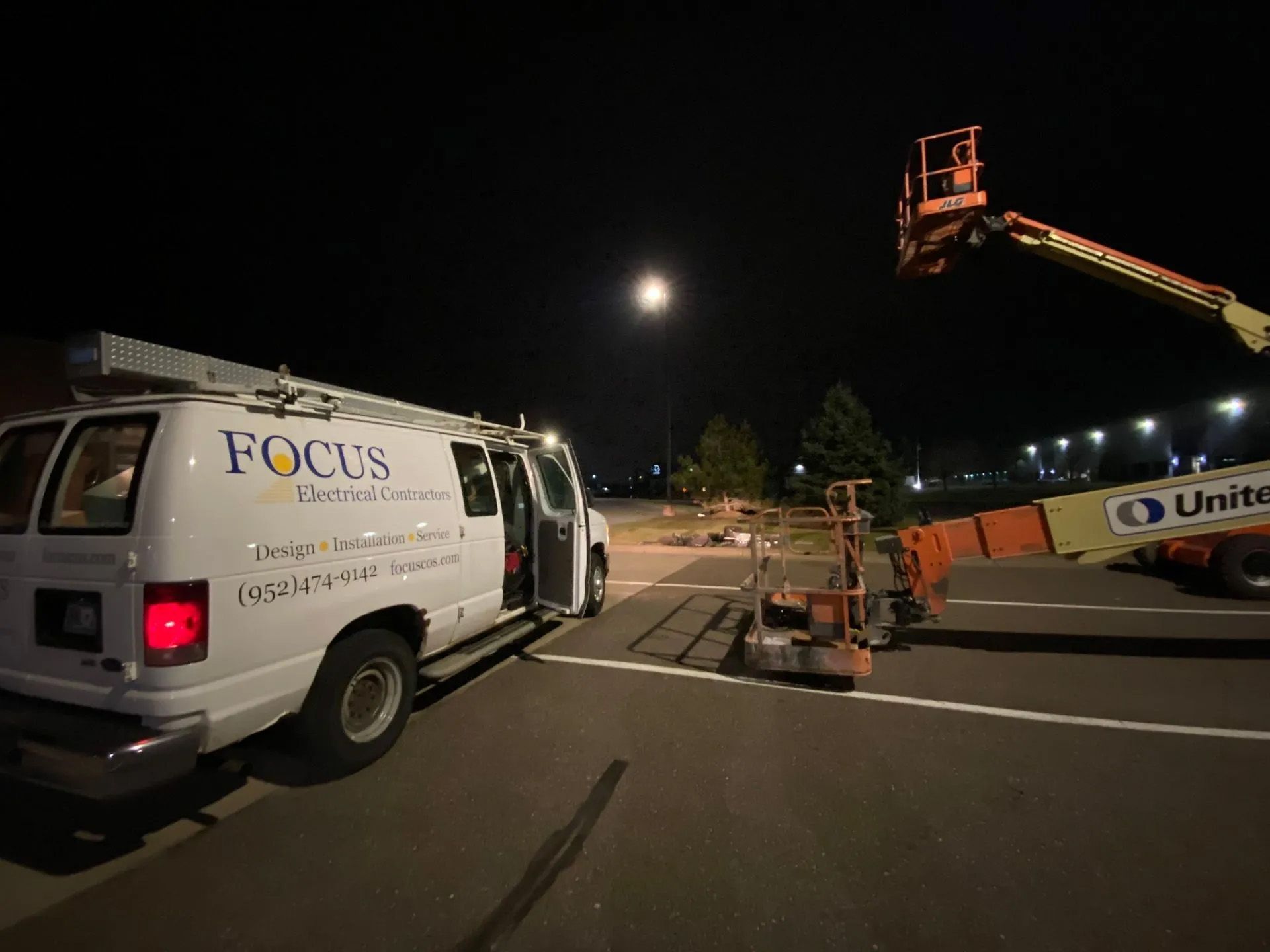A focus van is parked in a parking lot at night