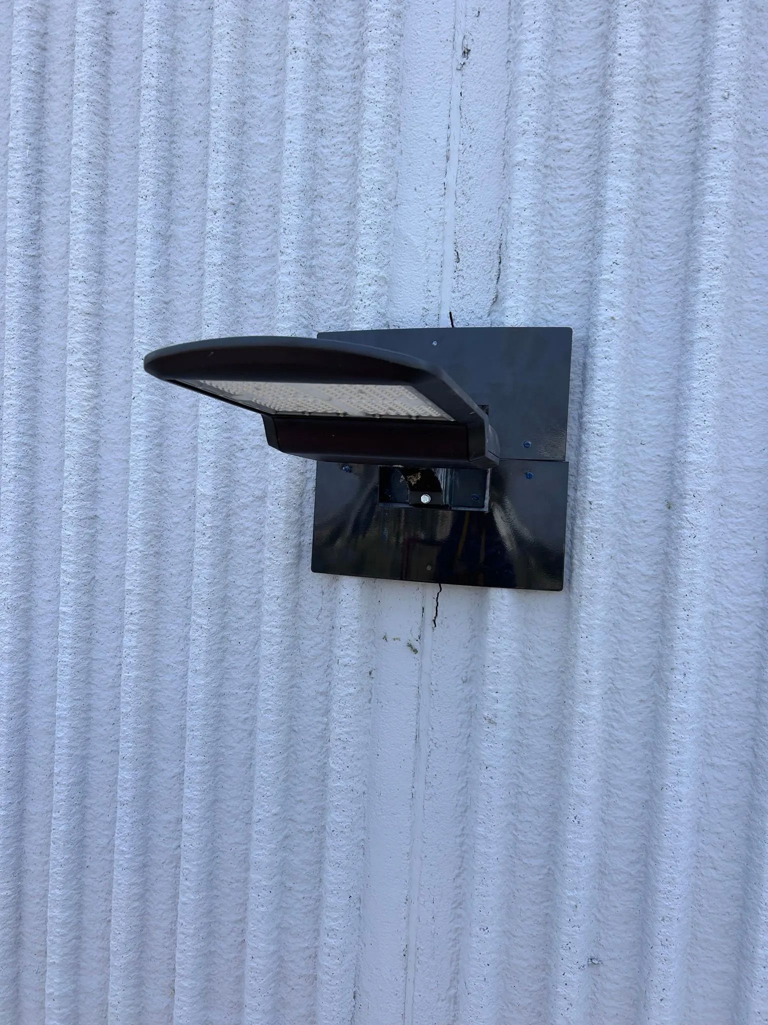 A black light is mounted on a white wall.