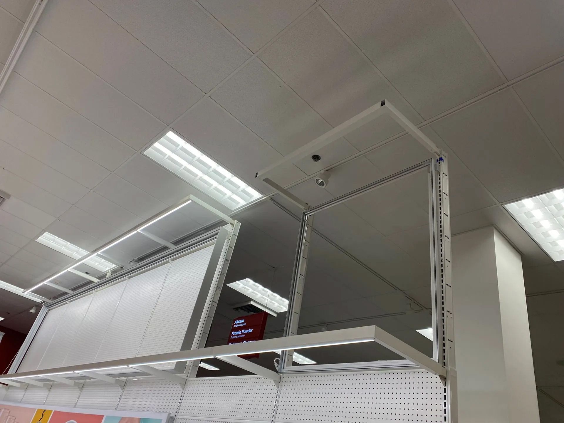 A store with a lot of shelves and a mirror on the ceiling.