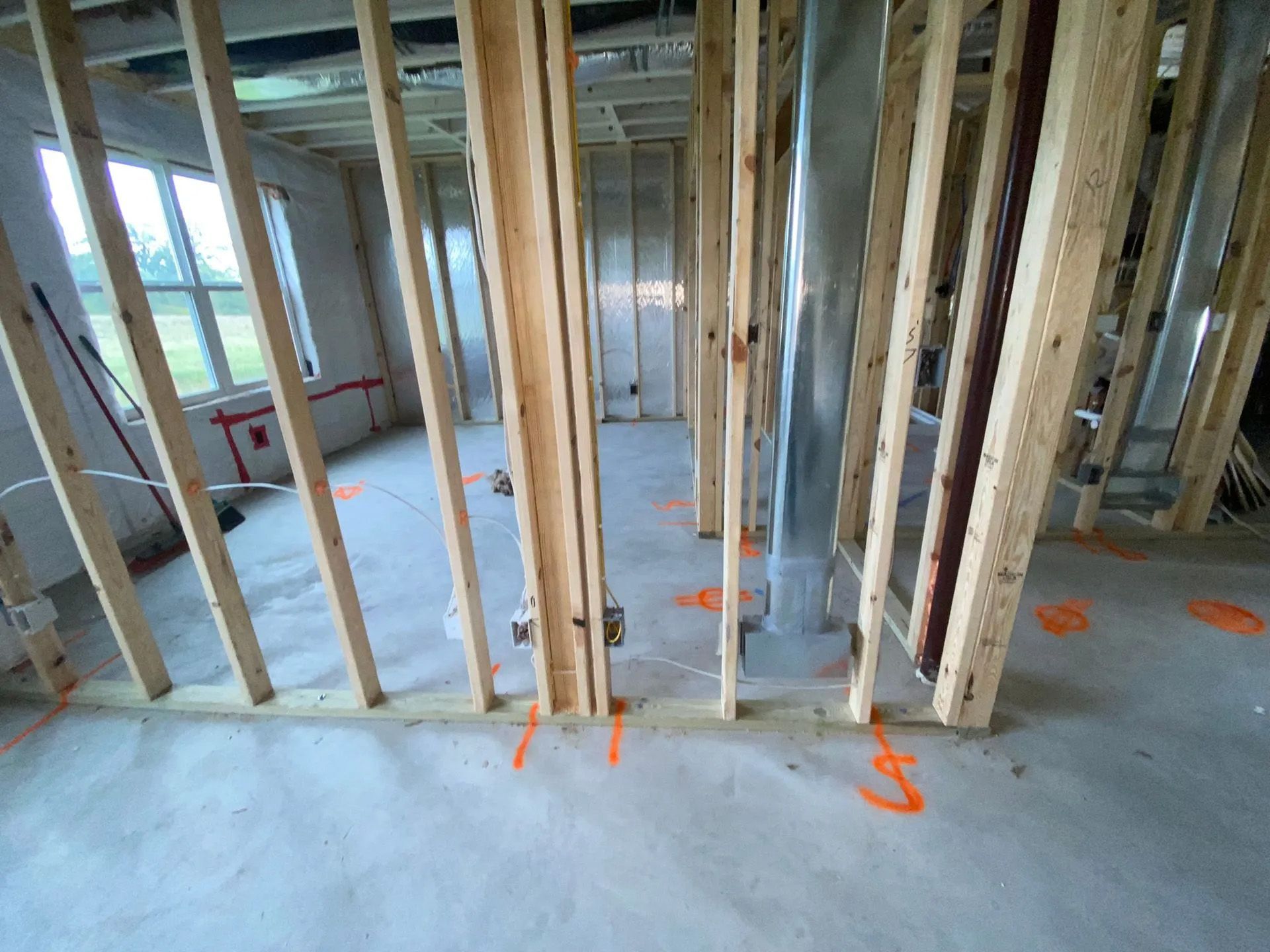 A room under construction with wooden beams and a concrete floor.
