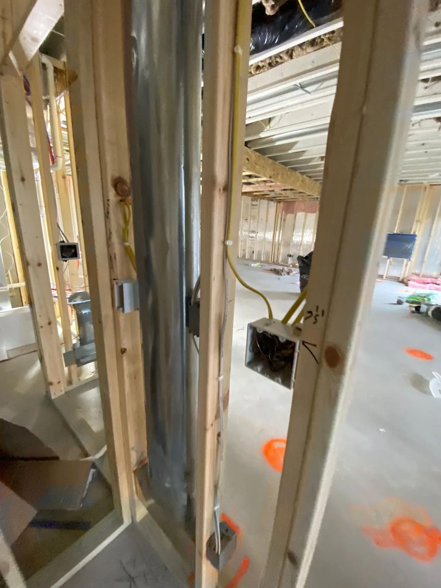 A room under construction with wooden beams and a metal pipe.