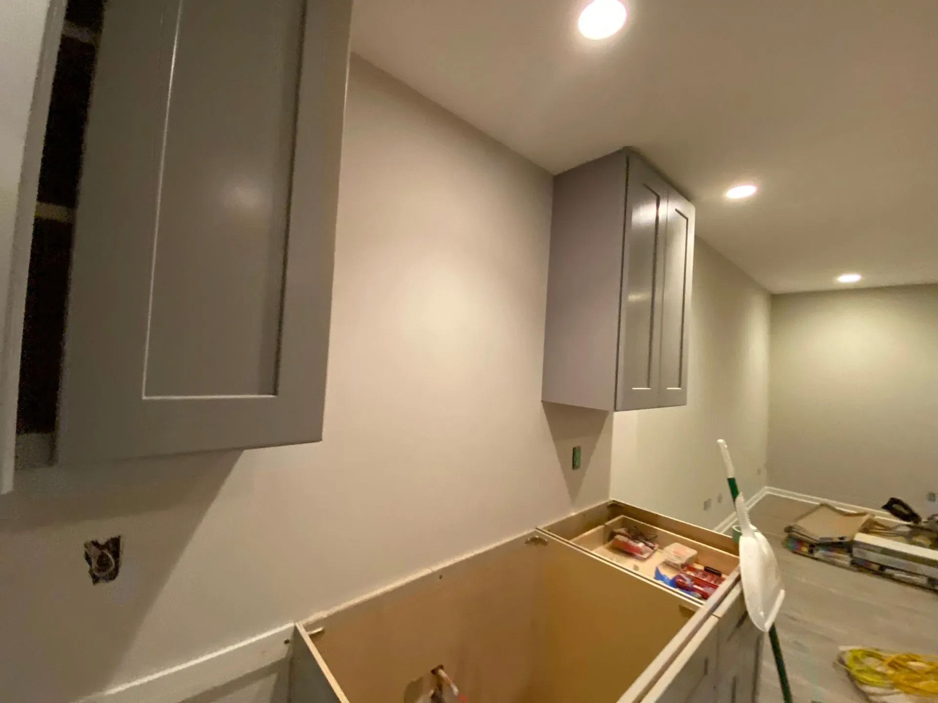 A kitchen with gray cabinets and white walls is being remodeled.