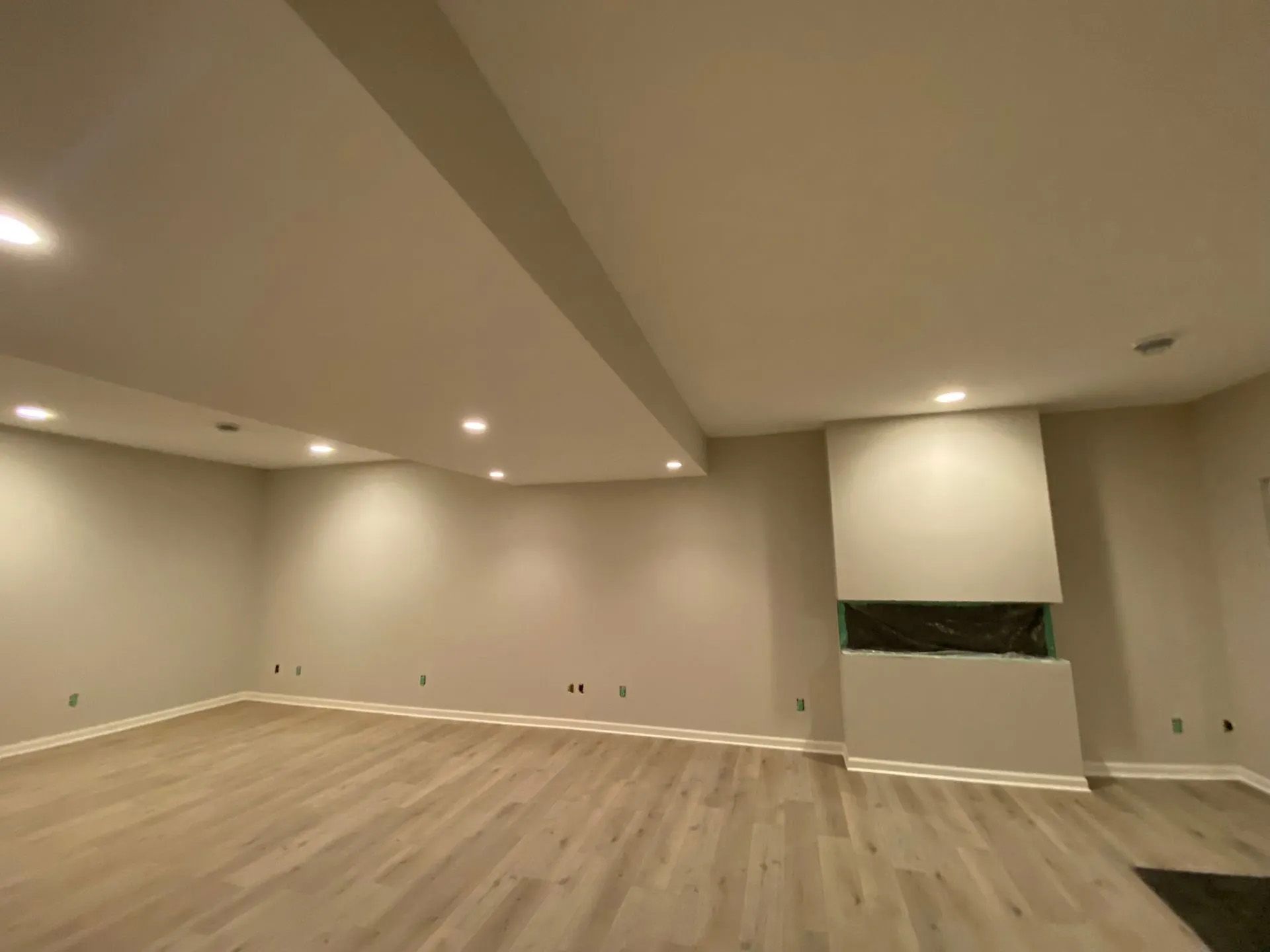 A large empty room with hardwood floors and a fireplace.