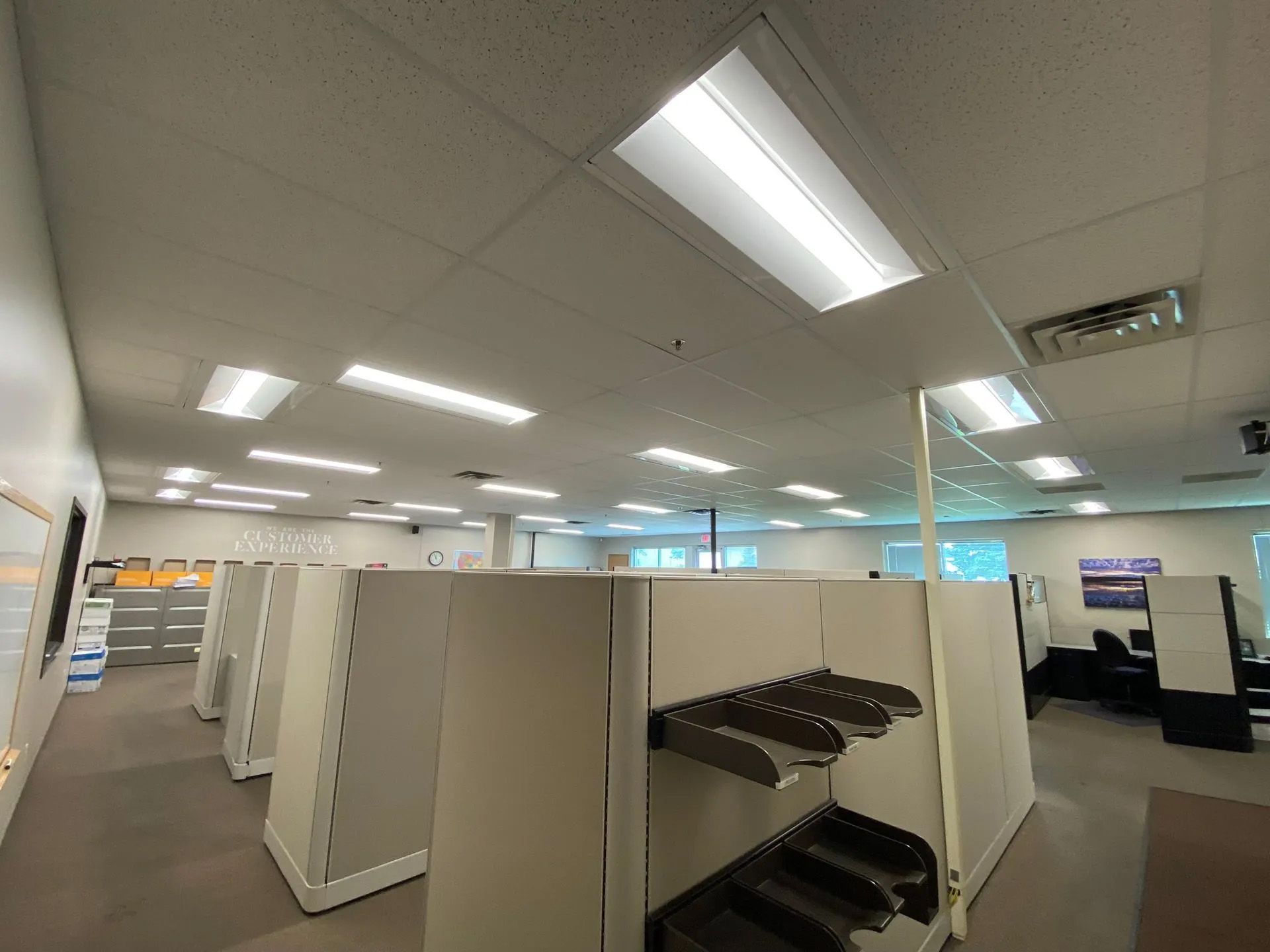 A large empty office with cubicles and shelves.