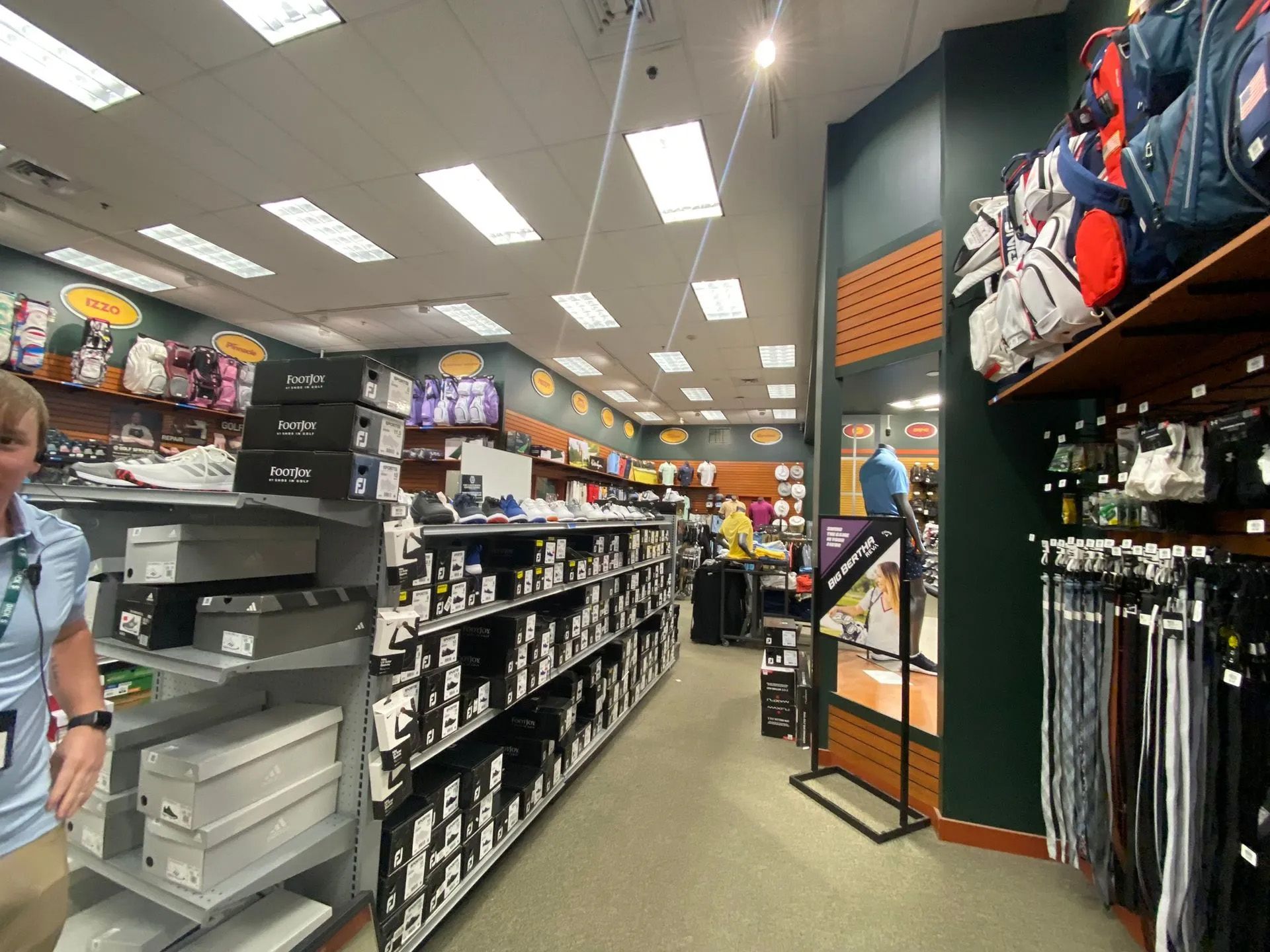 A woman is standing in a store looking at shoes
