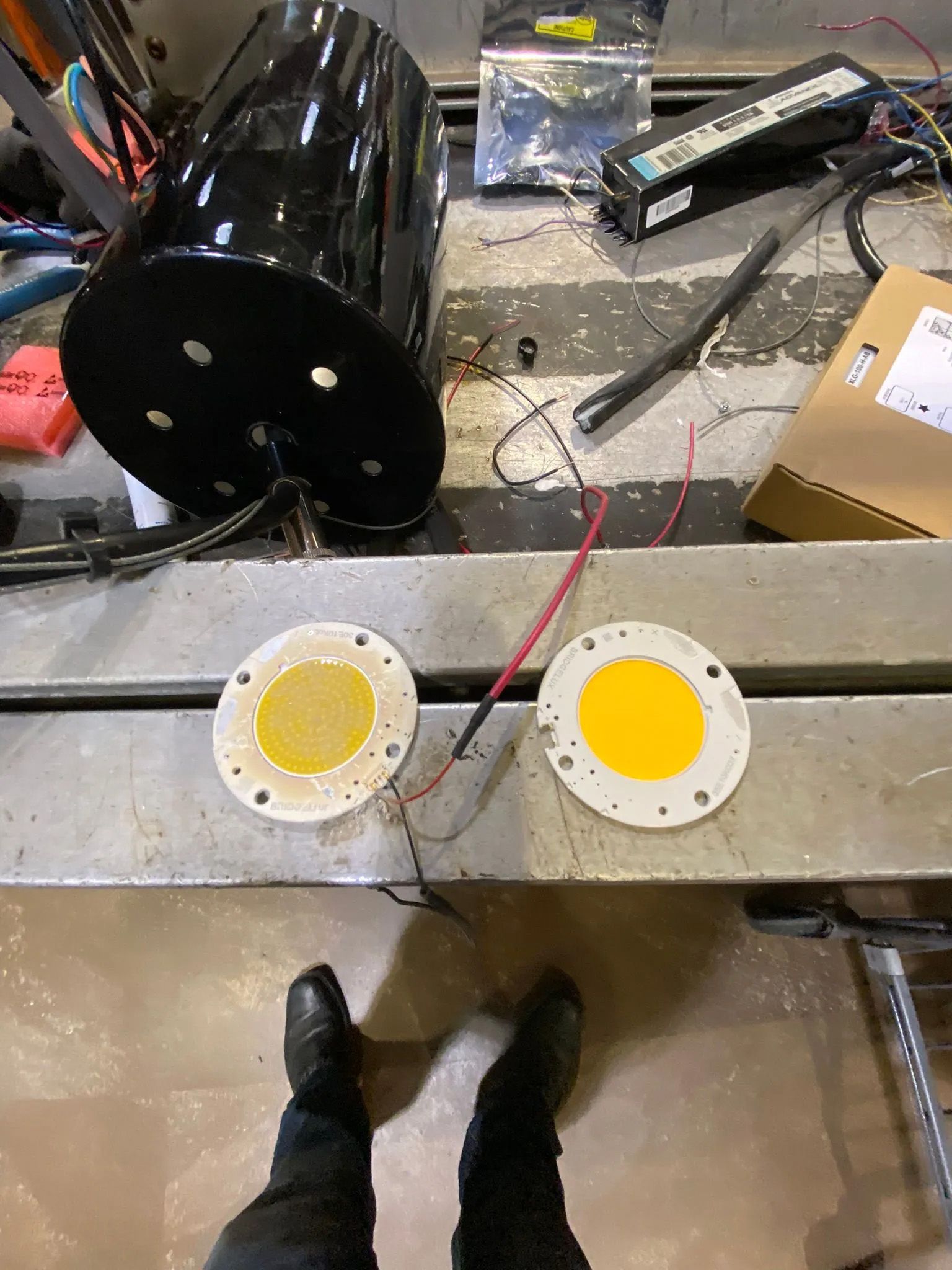 A person is standing next to a table with two lights on it.