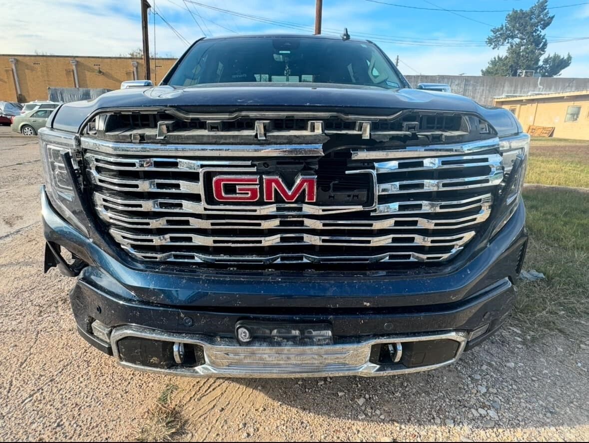 A black gm truck is parked in a parking lot.