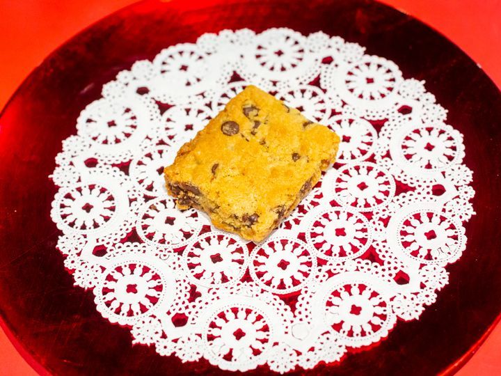 A chocolate chip cookie bar is sitting on a red plate