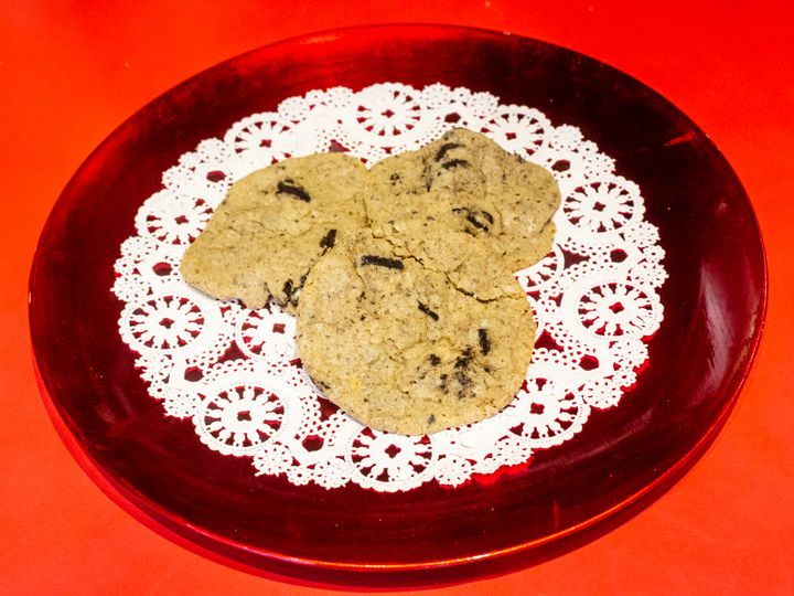 A red plate with three cookies on a white lace napkin
