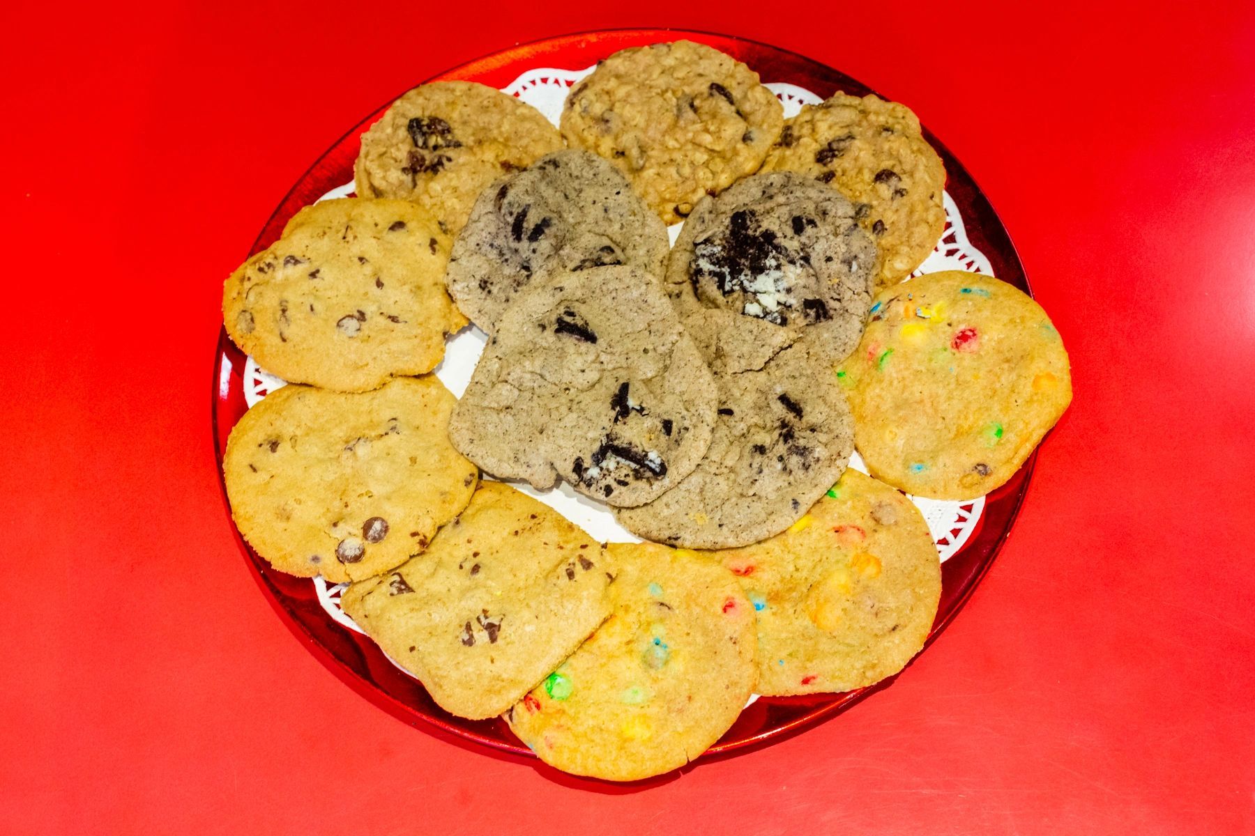 A plate of different types of cookies on a red table.