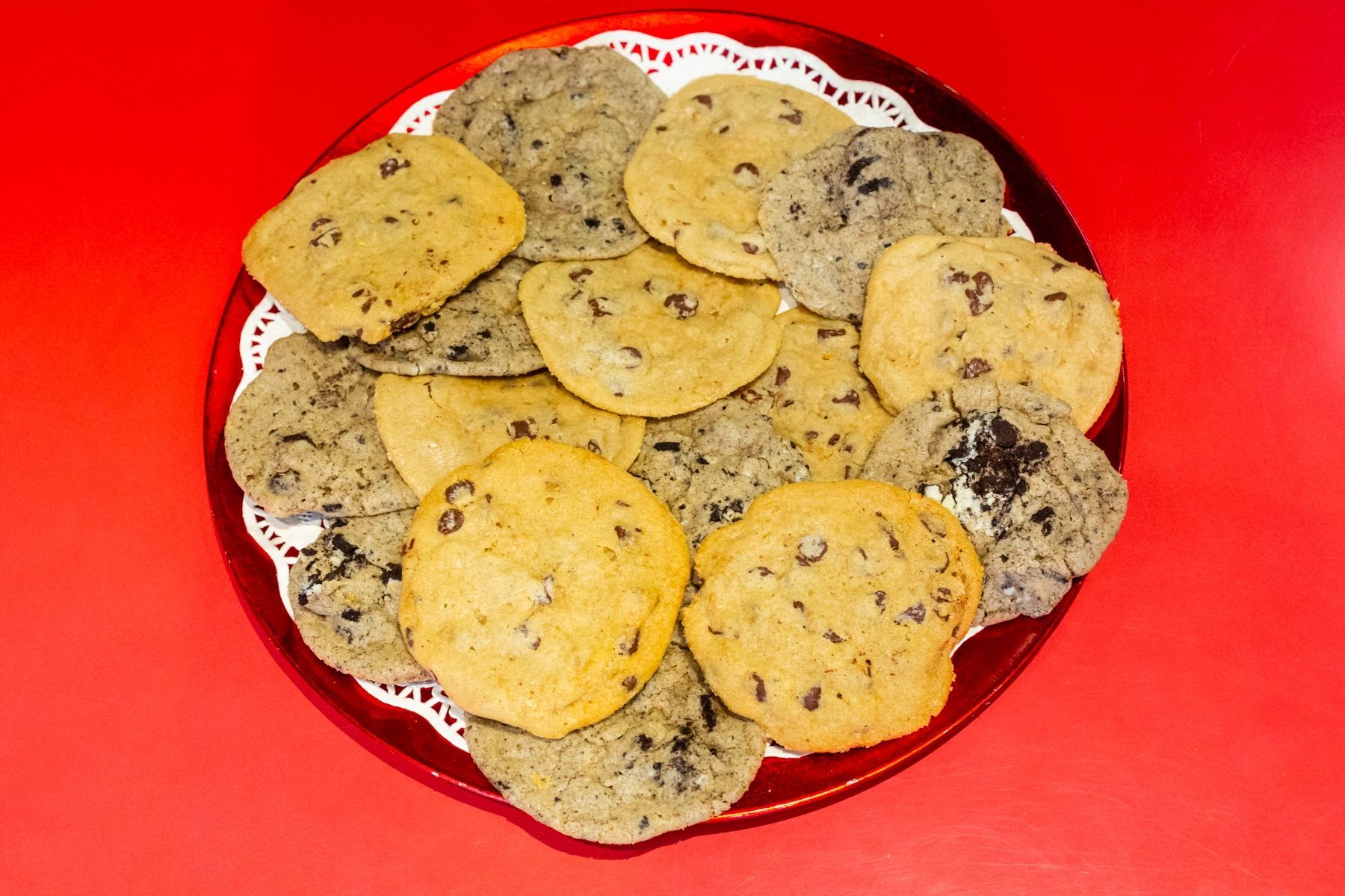 A plate of different types of cookies on a red table