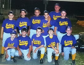A group of boys wearing purple bulldogs shirts pose for a picture
