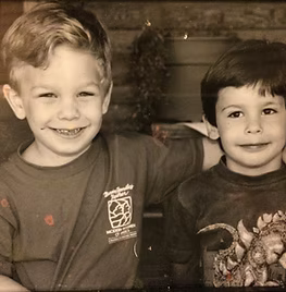 Two young boys are posing for a black and white photo.