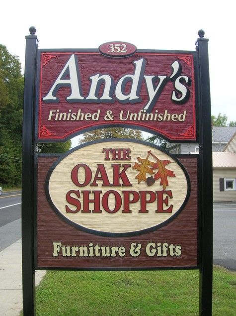 Sign for Andy's, a furniture store, with the Oak Shoppe beneath. Red, brown, and tan with black poles.