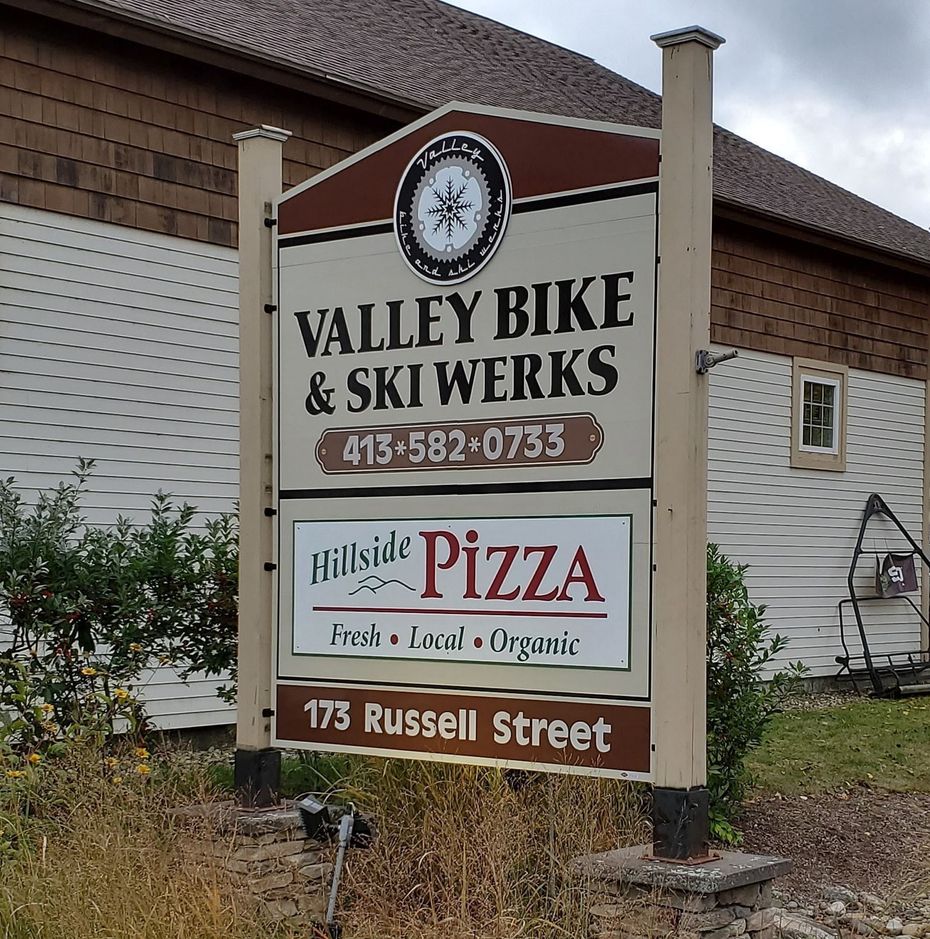Sign for Valley Bike & Ski Werks and Hillside Pizza at 173 Russell Street. Brown and white design.