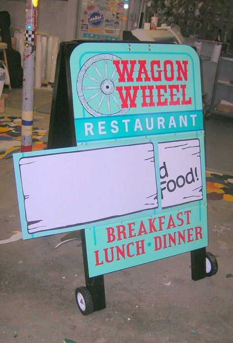 Wagon Wheel Restaurant A-frame sign. Turquoise with a wagon wheel logo, breakfast, lunch, dinner. Blank boards for specials.