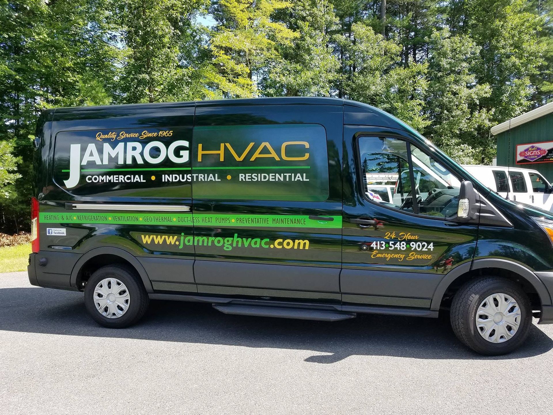 Dark green JAMROG HVAC van parked outdoors. Offers commercial, industrial, and residential services. 