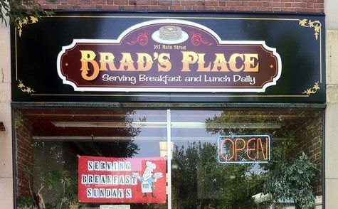 Brad's Place restaurant sign above a glass storefront, open sign in the window.