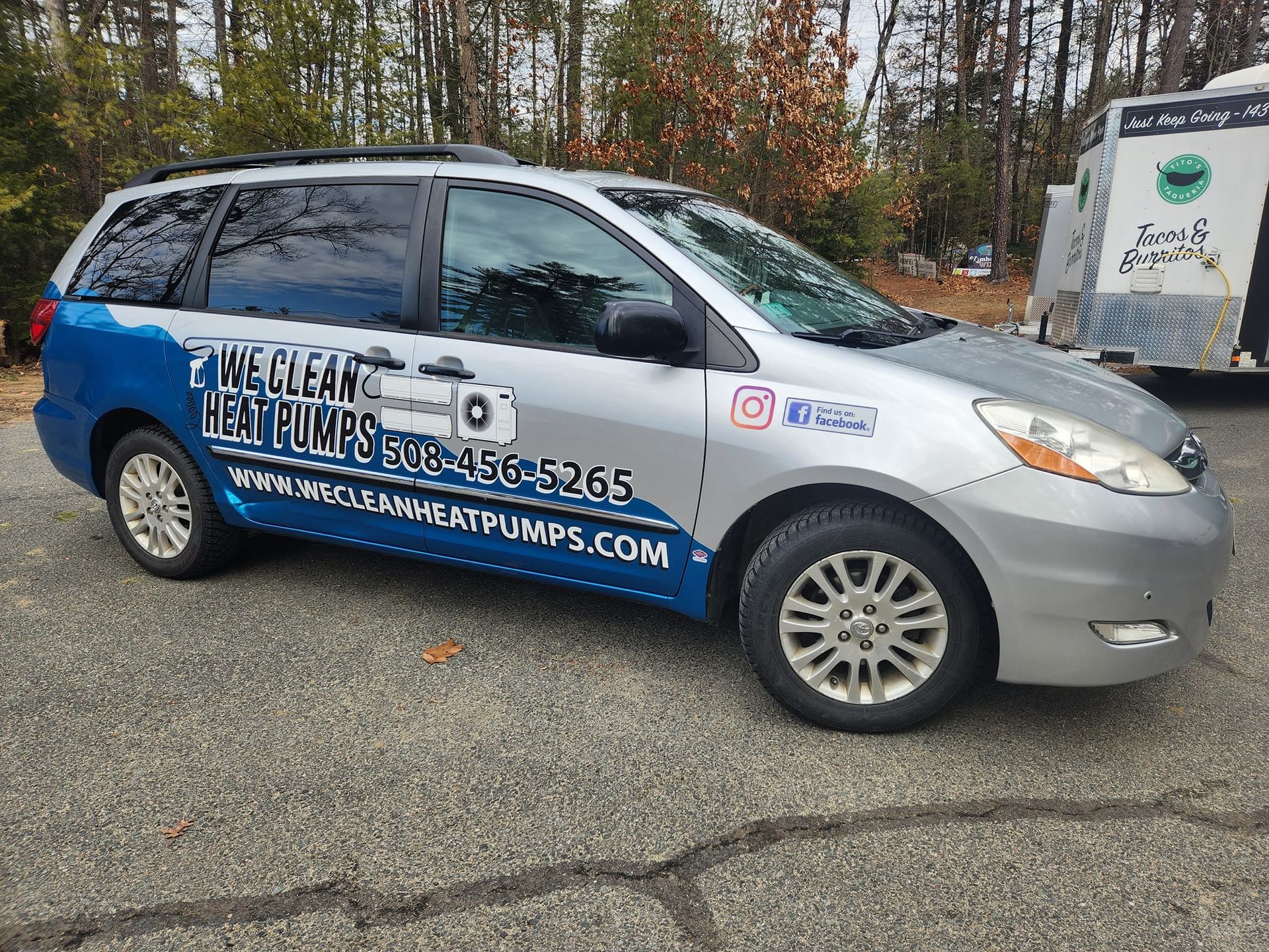 Silver minivan with blue accents advertising 