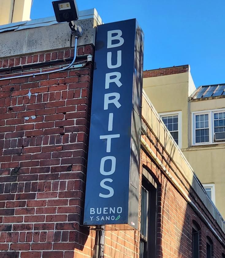 Black sign on brick building reads 