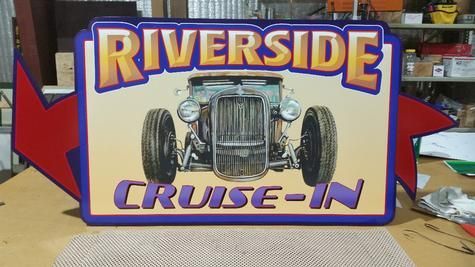 Sign for Riverside Cruise-In with a classic car image; purple, yellow, and red arrow.